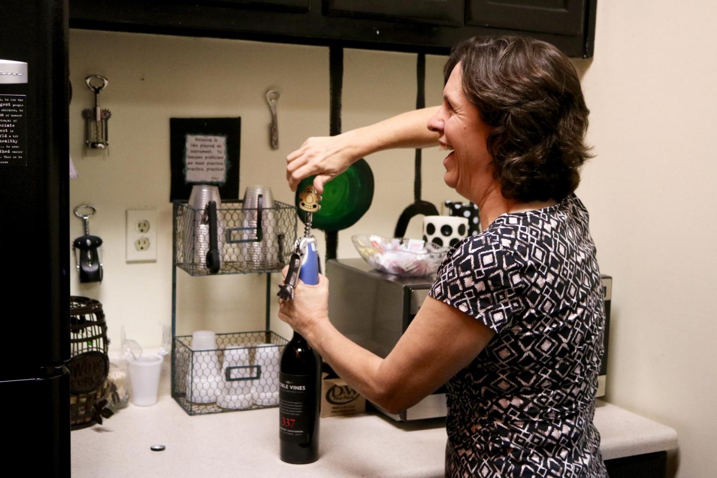 Pretty mom opening wine bottle