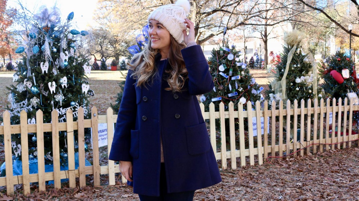 Katie in navy coat and white bobble hat